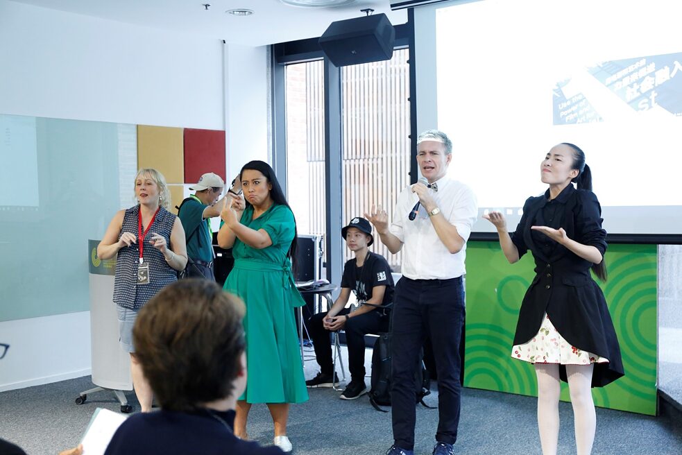 Oliver Hartman (second to the right) speaking at the 2018 Shanghai International Deaf Film Festival accompanied by three sign language interpreters: Tracey Arrowsmith (British sign language, first to the left), Alice Hu (International sign language, second to the left), and Tang Wenyan (Chinese sign language, first to the right)