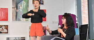 Sign language interpreter Tang Wenyan (left, standing) accompanying guest speaker Jin Xing (right, seated) during the Goethe Open Class 2019